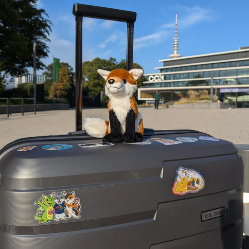 Photo of a little red fox plush sitting on a train seat table
